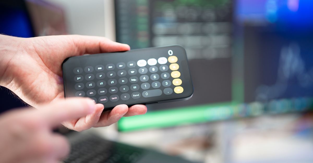 pessoa preocupada fazendo contas com a calculadora à mesa