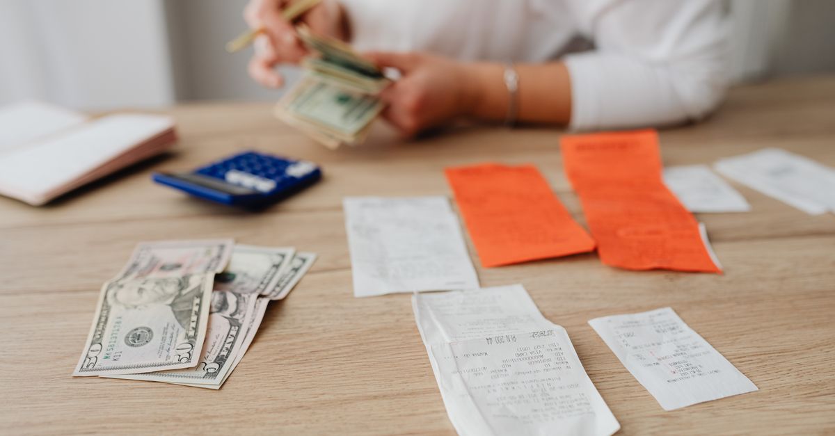 pessoa planejando as finanças à mesa com calculadora e caderno